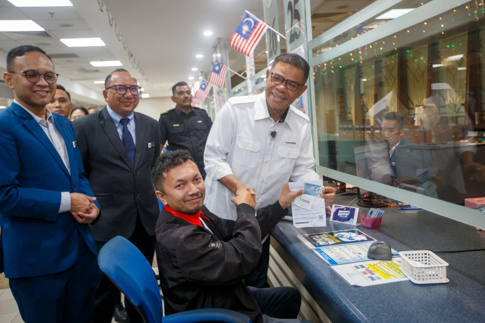 Home minister: Over 40,000 MyKad chip replacements after fee waiver Datuk Seri Saifuddin Nasution Ismail, Home Minister, interacts with a member of the public during his visit to the National Registration Department in Putrajaya September 23, 2025. — Picture by Raymond Manuel