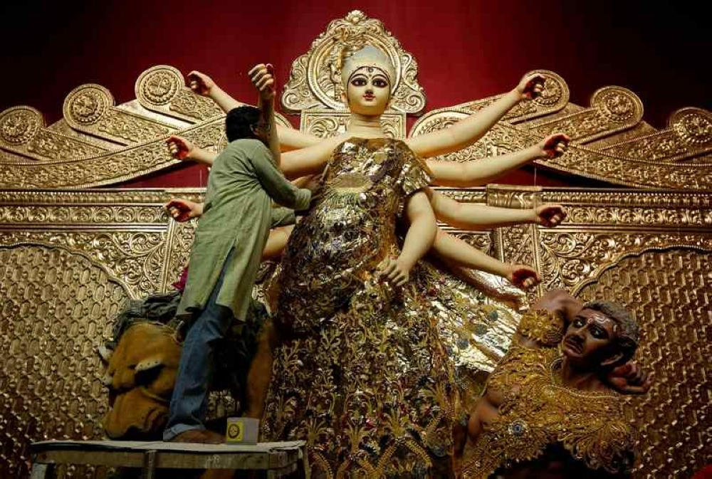 From ‘golu’ to ‘garbha’: How Hindus mark nine nights of Navaratri with devotion, fasting and cultural rituals An artisan adorns a gold saree on an idol of Hindu goddess Durga at a temporary platform called pandal, ahead of the Durga Puja festival in Kolkata September 23, 2017. — Reuters pic
