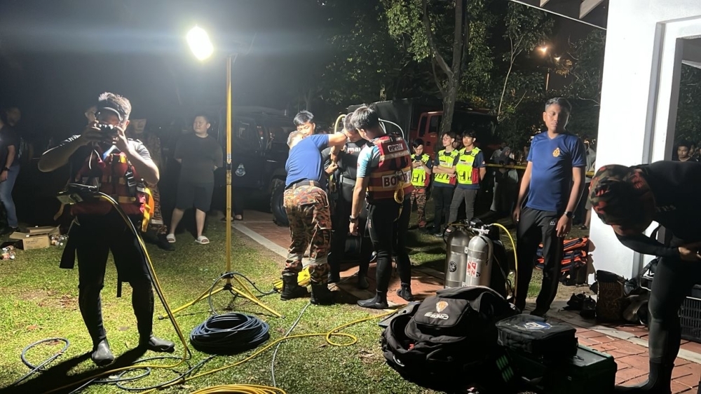 Two boys, aged 9 and 10, drown in Johor lake after going missing near water’s edge Divers from the Johor Fire and Rescue Department’s Water Rescue Team during the search and rescue operation for the two missing children at the Tasik Menawan lake in Taman Pelangi Indah, Johor Bahru early this morning. — Picture courtesy of the Johor Fire and Rescue Department