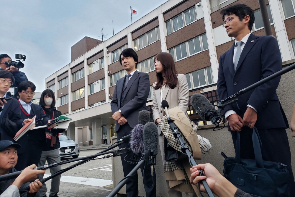 Riho Fukuyama (centre) and her husband Yoshiki speak to the media outside the Toyama District Court on October 21, 2025. after her father was jailed eight years for raping her when she was in high school. — AFP pic Riho Fukuyama (centre) and her husband Yoshiki speak to the media outside the Toyama District Court on October 21, 2025. after her father was jailed eight years for raping her when she was in high school. — AFP pic