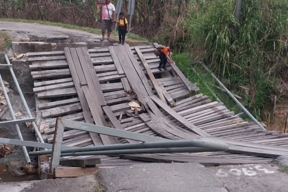 Main bridge collapses in Keningau, forcing hundreds of villagers onto hour-long detour A wooden bridge that directly linked Kampung Tigot to Keningau town in Sabah for decades has collapsed, forcing residents to use an alternative route through Jalan Baginda to Binaung, which takes more than an hour to reach town compared to the previous 15-minute journey. — Daily Express pic