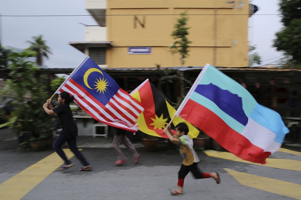 BM vs English Constitution? Sabah lawyers demand safeguards for Borneo states’ rights Sabah Law Society yesterday filed a court case to seek to uphold the Federal Constitution’s requirements if there are any moves to make the Constitution’s Bahasa Malaysia translation as the authoritative text. File photo in 2018 of children holding the flags for Malaysia, Sabah and Sarawak. — Picture by Yusof Mat Isa