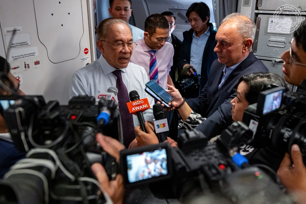 Anwar says political secretary’s letter didn’t result in project approval, reprimand sufficient Prime Minister Datuk Seri Anwar Ibrahim speaks to the media on board a flight to Johannesburg, South Africa, on Nov 21, 2025. — Anwar Ibrahim/Facebook pic