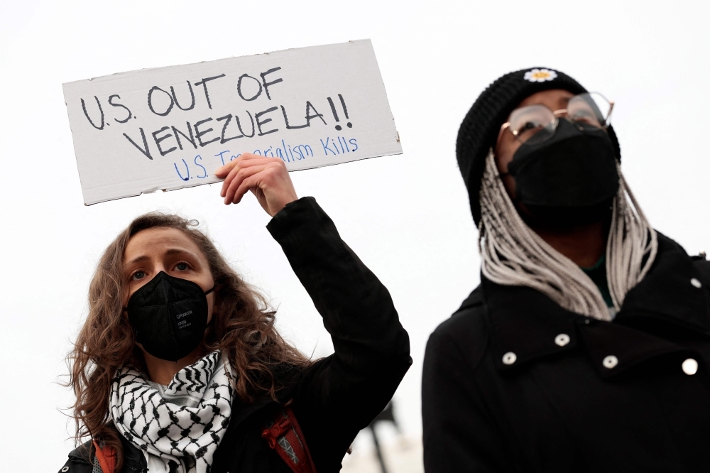 Trump claims control over 50 million barrels as Venezuela interim government pledges oil to US Protesters hold signs during a demonstration against U.S. military action in Venezuela on January 06, 2026 in Washington. — AFP pic