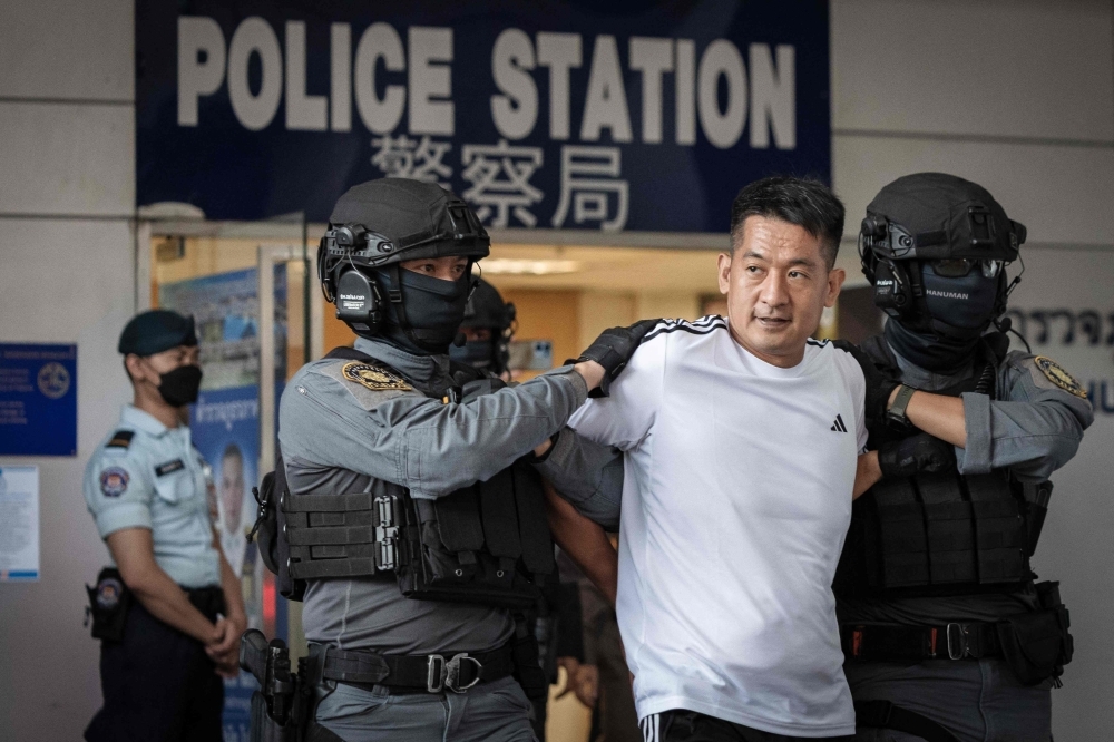 ‘Continued combat’: Cambodia to keep up crackdown on scam centres after arrest of alleged mastermind Chinese businessman She Zhijiang (2nd R) is escorted by Royal Thai Police out of the Suvarnabhumi Airport Police Station in Bangkok on November 12, 2025, before being extradited to China. — AFP pic