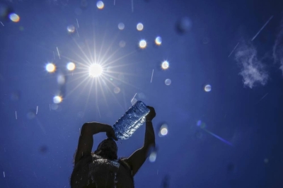 FILE - A man pours cold water onto his head to cool off on a sweltering hot day in the Mediterranean Sea in Beirut, Lebanon. Photo: AP