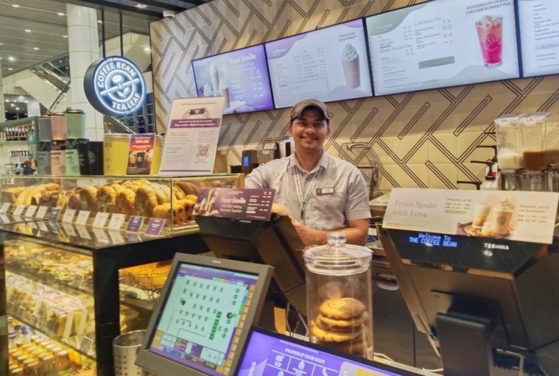 Umesh Gajmer 在马来西亚吉隆坡国际机场的咖啡豆和茶叶店摆姿势拍照。照片:THT