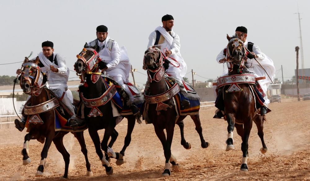 سباق خيول باللباس الليبي التقليدي أثناء المشاركة في عرس بمدينة قرب العاصمة طرابلس. (رويترز)