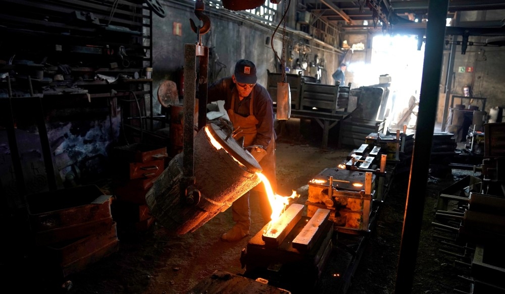 عامل داخل مصنع للصلب في إسبانيا يسكب الحديد المنصهر في القوالب. (رويترز)