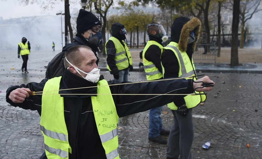 متظاهر من السترات الصفراء يستعمل مقلاعاً للقذائف - في باريس / أ ف ب