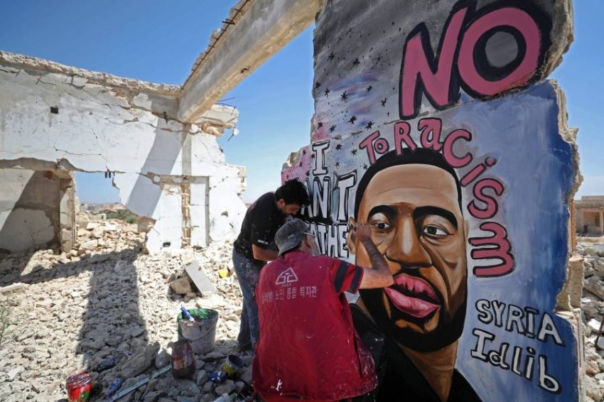 فنان سوري يتضامن مع فلويد بغرافيتي على أطلال منزل في إدلب