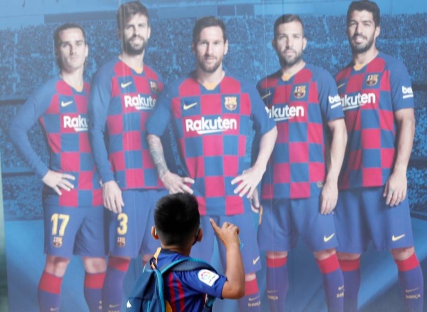 طفل ينظر إلى لوحة إعلانية لفريق برشلونة. (رويترز)