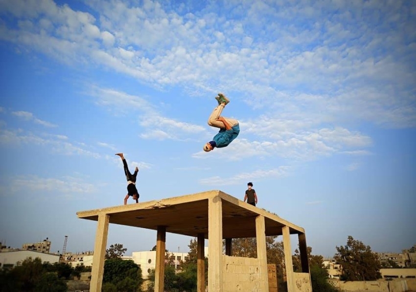 لاعبو الباركور يمارسون هوايتهم بين جدران مقابر غزة المتهالكة