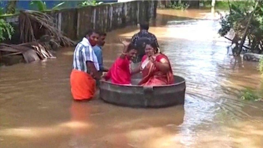 بالفيديو.. عروسان يحولان إناء طهي لمركب يجوب شوارع غمرتها الفيضانات