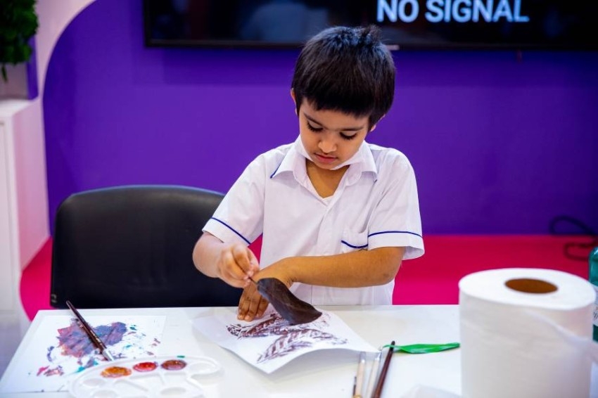 أطفال يرسمون بأوراق الشجر في «الشارقة للكتاب»