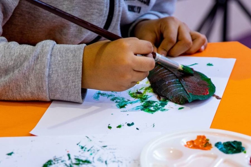 أطفال يرسمون بأوراق الشجر في «الشارقة للكتاب»