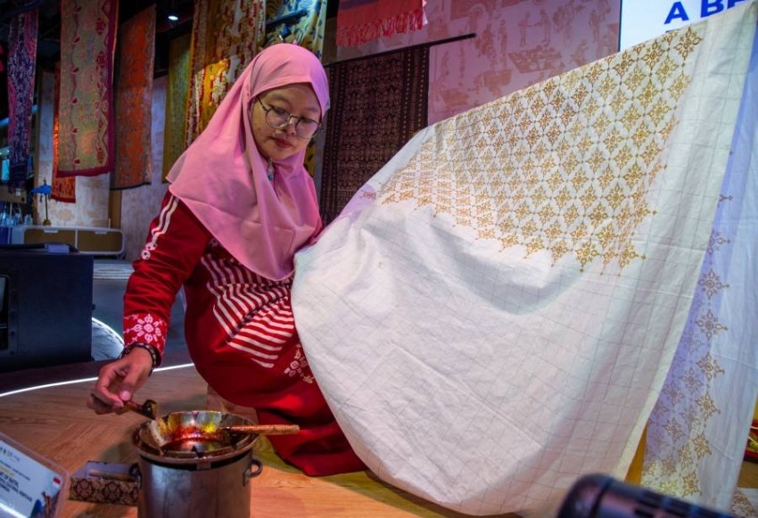 حرفيات إندونيسيا يبهرن زوار إكسبو بطباعة «الباتيك» على المنسوجات