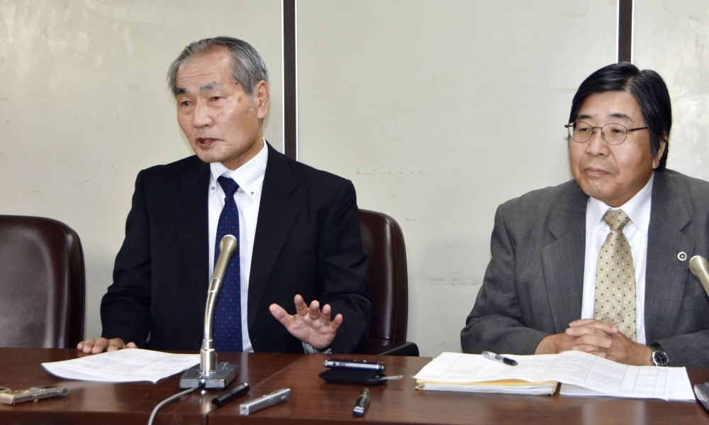 Haruhiko Aoyama (left), one of the plaintiffs of a lawsuit over significant base pay cuts after reaching the retirement age and being reemployed, speaks to reporters in Tokyo Thursday following a ruling by the Supreme Court.