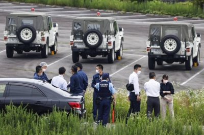 Police officers gather at a Ground Self-Defense Force shooting range in Gifu Prefecture on June 14 following a fatal rifle attack.