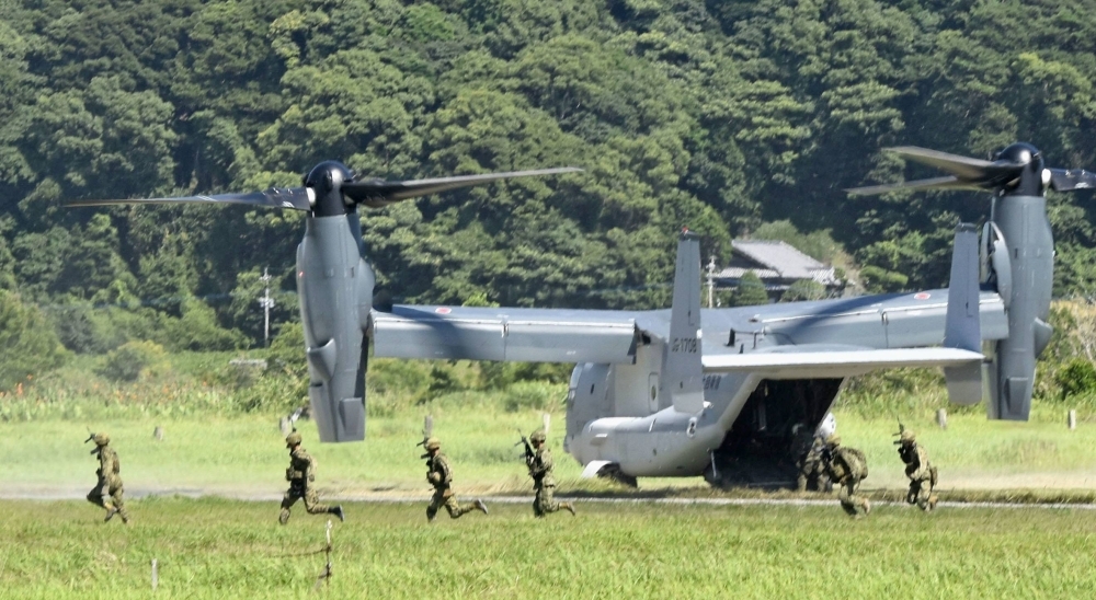 Members of the Ground Self-Defense Force's Amphibious Rapid Deployment Brigade disembark from a V-22 Osprey at Camp Ainoura in Sasebo, Nagasaki Prefecture, in July 2022.