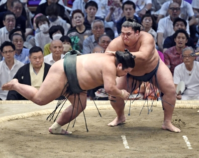 Shonannoumi (right) defeats Nishikigi on Day 12 of the Nagoya Grand Sumo Tournament on Thursday.