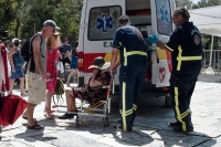 Medics help a woman who had passed out from the heat in Athens, Greece, on Thursday. | Bloomberg