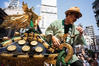 A man stands atop a float holding a portable shrine at this year’s Sanja Festival in Tokyo.