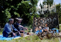 Ainu men sit in front of a makeshift altar to hold a memorial service for Ainu tribesmen defeated by Japanese soldiers in a 15th century battle in Kaminokuni, Hokkaido. | Reuters 