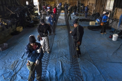 Employees of a fishing net manufacturer, including Ainu Indigenous people, work at a facility in Urahoro, Hokkaido, in June. 