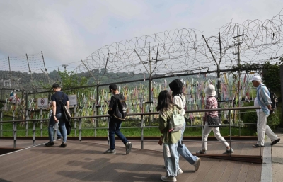 Visitors walk past a military fence at Imjingak peace park in the border city of Paju on Wednesday. 