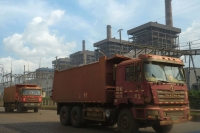 Dump trucks travel in front of a power plant in the Indonesia Morowali Industrial Park. | Bloomberg