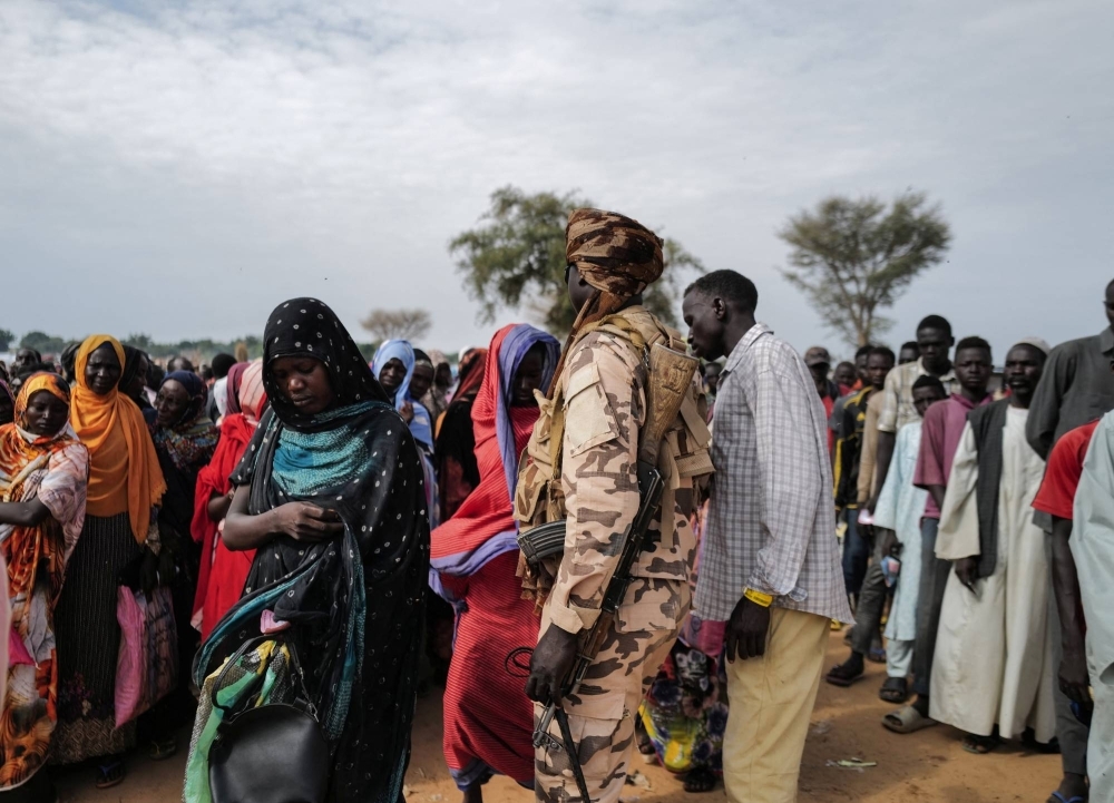 Sudanese refugees line up to receive food rations from World Food Programme, in Adre, Chad, on Thursday