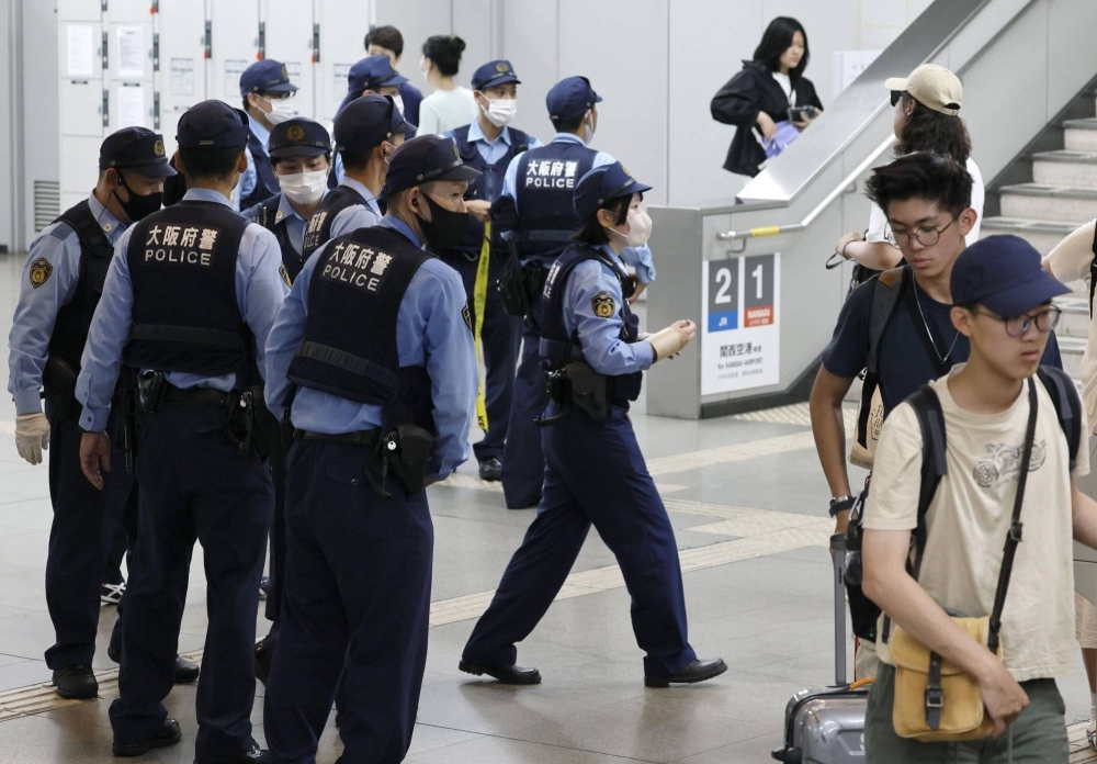 Police officers gather at Rinku Town Station in Izumisano, Osaka Prefecture, where they apprehended the suspect in a train attack on Sunday. 