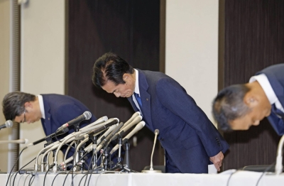 Bigmotor President Hiroyuki Kaneshige (center) apologizes for improper conduct by the company's employees at a news conference in Tokyo on Tuesday.