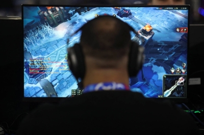 A man plays video games in Sao Paulo, Brazil, on Tuesday. As AI platforms advance at breakneck speeds, hundreds of thousands of jobs in the gaming sector become at risk of being replaced by the technology.