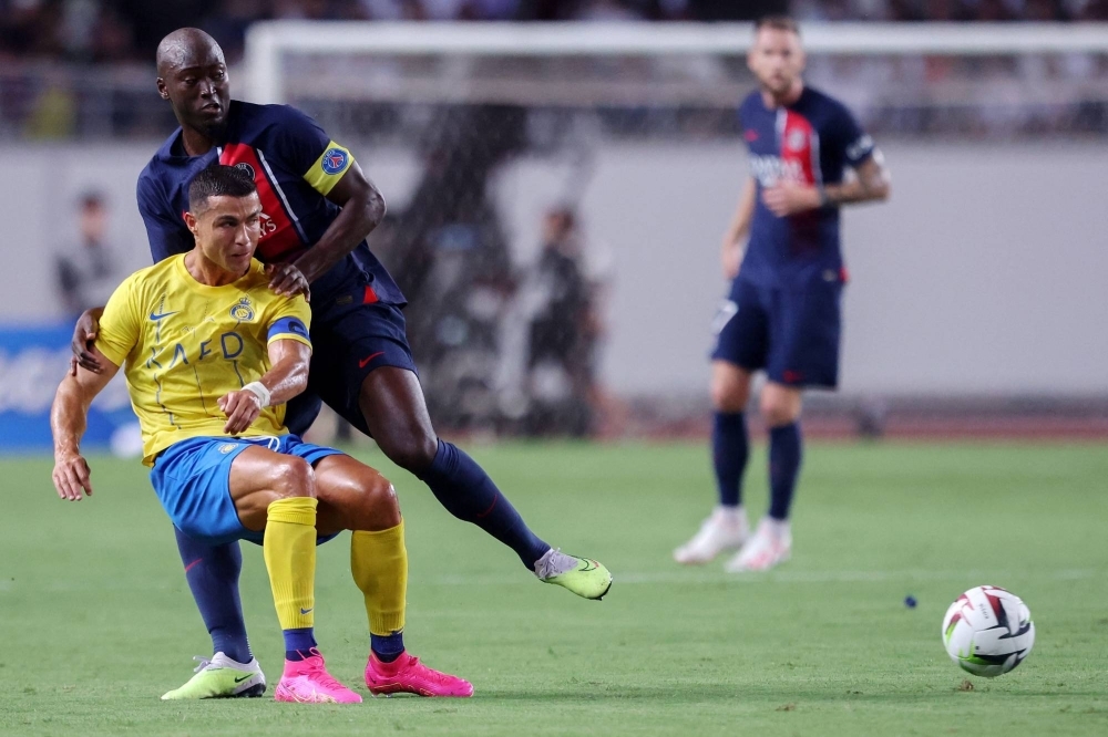 Al Nassr's Cristiano Ronaldo (left) fights for the ball with PSG's Danilo Pereira during an international club friendly in Osaka on Tuesday.