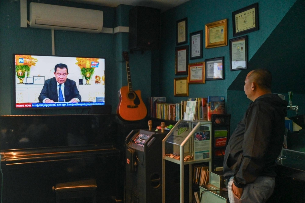 A man watches as Cambodia's Prime Minister Hun Sen speaks during a special statement on television at a restaurant in Phnom Penh on Wednesday. Hun Sen, one of the world's longest-serving leaders, said he will resign and hand power to his son, after almost four decades of hardline rule. 