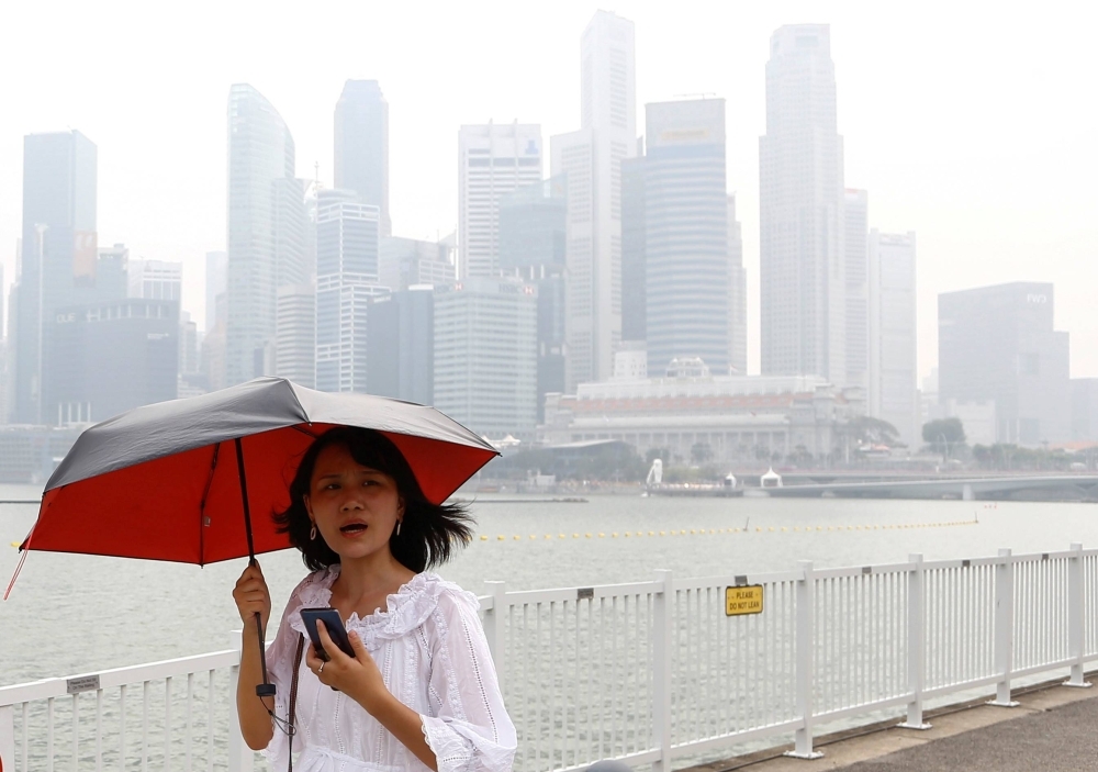 A woman passes by the financial district shrouded by haze in Singapore in 2019.