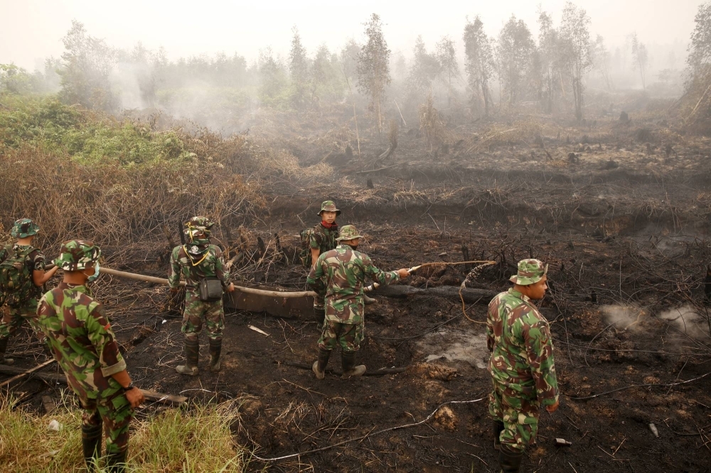 Indonesian soldiers spray water on a peatland fire in central Kalimantan, Indonesia, in 2015.