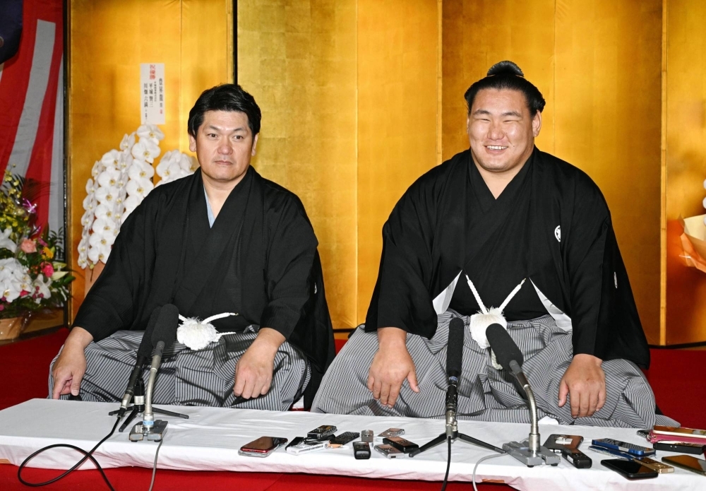 Hoshoryu (right), joined by Tatsunami stablemaster, participates in a news conference following his promotion to ozeki in Nagoya on Wednesday.