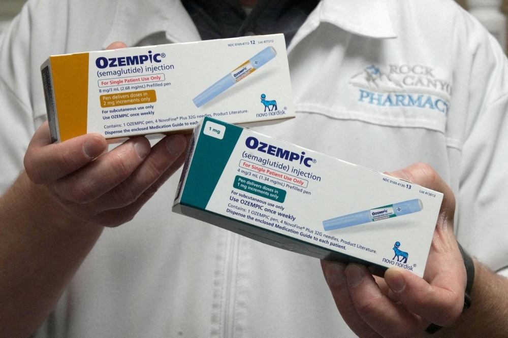 A pharmacist displays boxes of Ozempic, a semaglutide injection drug used for treating type 2 diabetes and obesity made by Novo Nordisk.