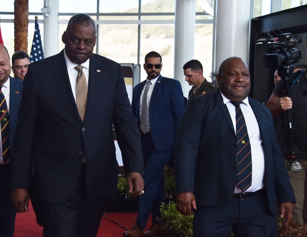 U.S. Defense Secretary Lloyd Austin (left) and Papua New Guinea Defense Minister Win Bakri Daki walk to their meeting in Port Moresby on Thursday.