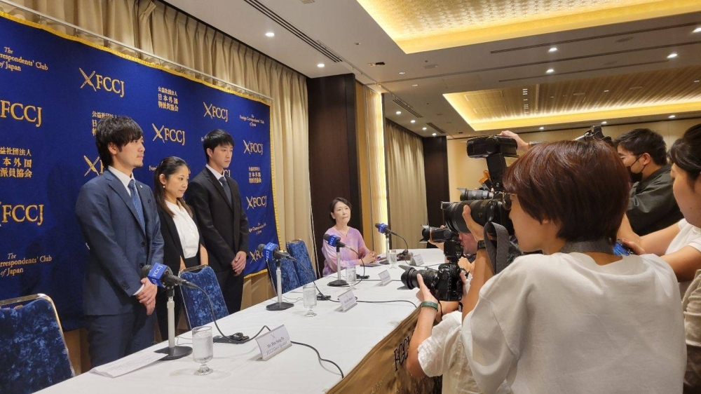 Members of the media take photos of lawyers Hsu Sung Po (left) and Aiko Ohbuchi (center) and Taiwanese table tennis player Chiang Hung-chieh at the Foreign Correspondents' Club of Japan on Thursday.
