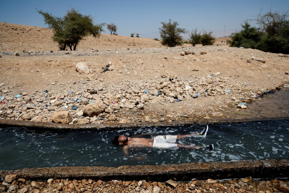 A Palestinian man cools off during a heat wave in the al-Oja Springs near Jericho in the Israeli-occupied West Bank, on July 18.