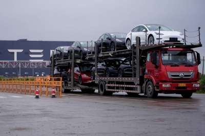 A truck transports new Tesla cars at its factory in Shanghai in May 2021.
