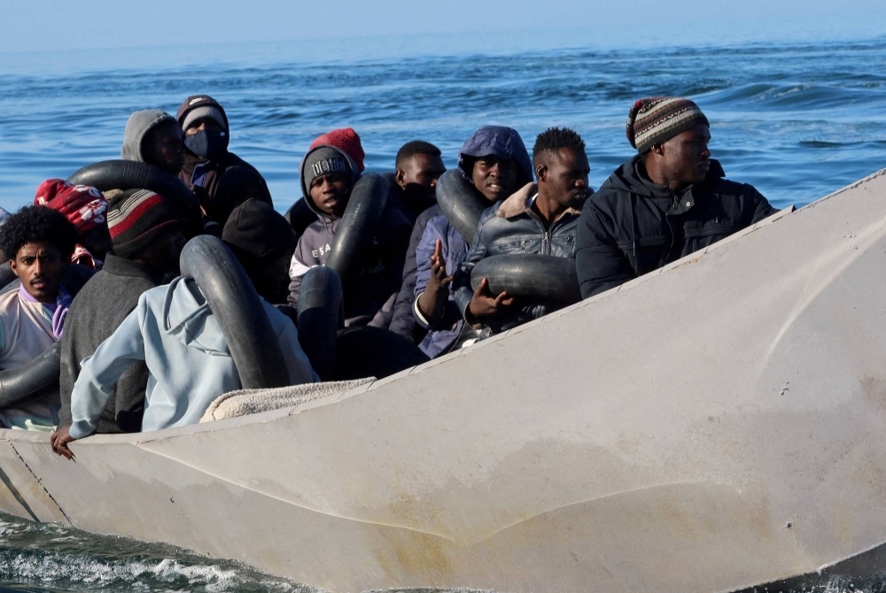 Migrants are seen on a metal boat as members of the Tunisian coastguard try to stop them at sea during their attempt to cross to Italy, off Sfax, Tunisia, on April 27.