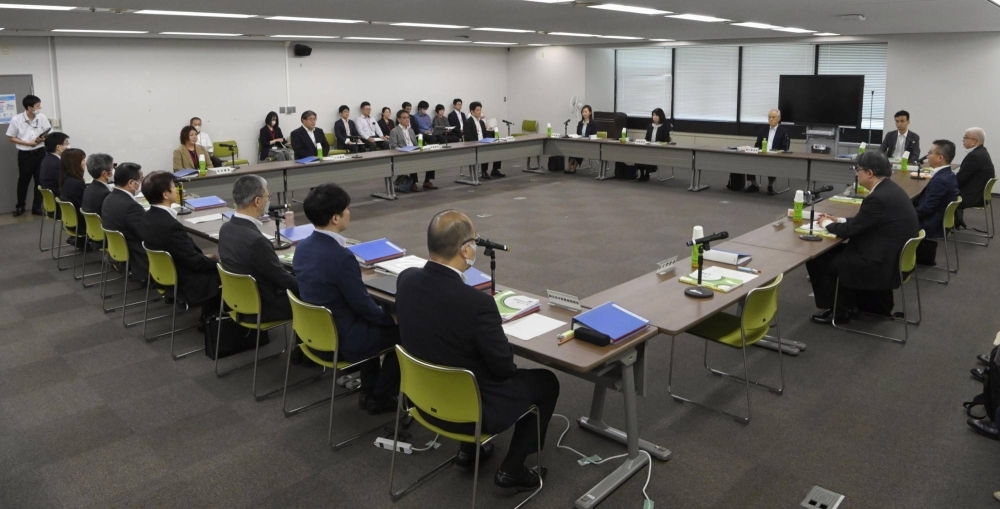 Members of a labor ministry panel on wages meet in Tokyo on Friday.