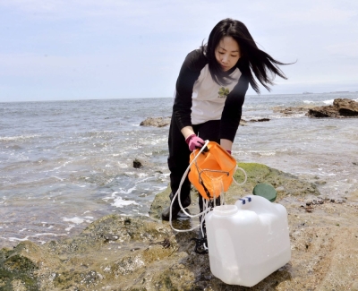 Noriko Tanaka of the NPO Mothers' Radiation Lab Fukushima — Tarachine collects seawater samples to measure for radioactive materials in Iwaki, Fukushima Prefecture, on June 13.