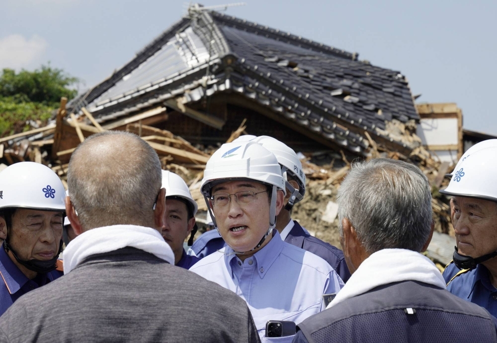 Prime Minister Fumio Kishida visits an area in the city of Kurume, Fukuoka Prefecture, which was damaged by heavy rain earlier this month, on Thursday.