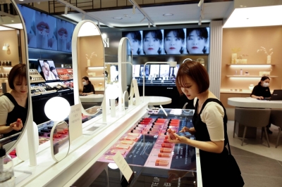 A woman shops for cosmetics at a department store in Seoul in July 2020.